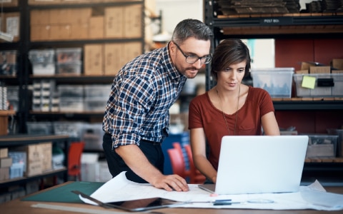 Two people looking at information on a laptop computer